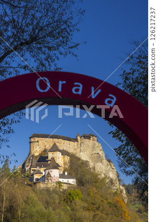 Orava Castle rising above autumn trees under clear blue sky 126217237