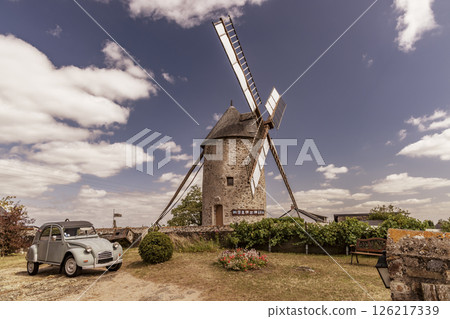 Old windmill standing tall in Chaudefonds sur Layon, France, under a cloudy sky 126217339