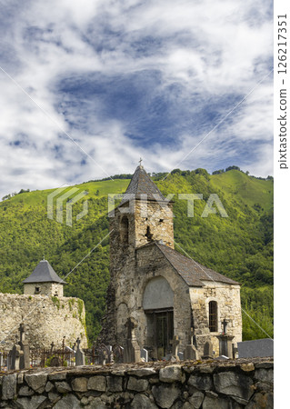 Old church and cemetery overlooking the green Pyrenees mountains in Ustou, France Old church and cemetery overlooking the green Pyrenees mountains in Ustou, France 126217351