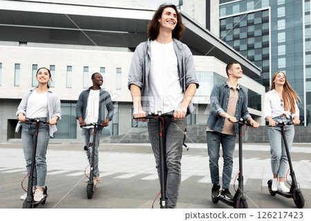 Best Buddies. Full length portrait of five stylish multiracial teenagers riding electric push scooters in urban area 126217423