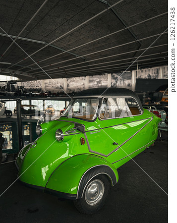 The photo shows a bright green retro microcar. 126217438