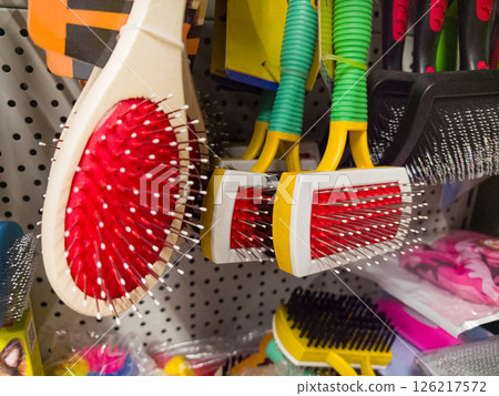 Colorful grooming tools displayed on a pegboard in a store aisle Colorful grooming tools displayed on a pegboard in a store aisle 126217572