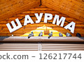 Facade with signboard of fast food restaurant Shawarma. Inscription in Russian: Shawarma 126217744