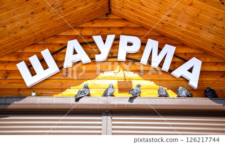 Facade with signboard of fast food restaurant Shawarma. Inscription in Russian: Shawarma 126217744