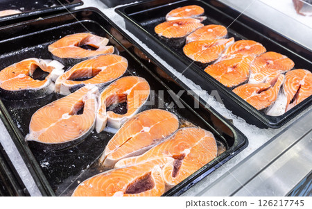 Steaks of fresh salmon fish on the counter. Raw red fish for sale. Seafood shop Steaks of fresh salmon fish on the counter. Raw red fish for sale. Seafood shop 126217745