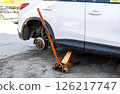 Car without wheels and lift up by jack stand .Waiting for tire replacement. 126217747