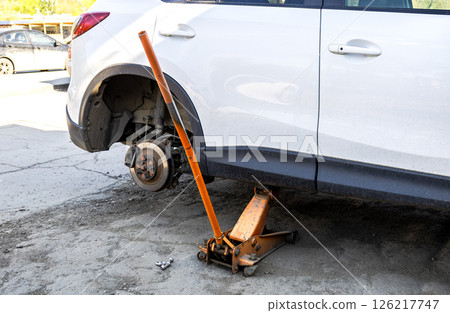 Car without wheels and lift up by jack stand .Waiting for tire replacement. 126217747