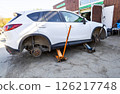 Car without wheels and lift up by jack stand .Waiting for tire replacement. 126217748