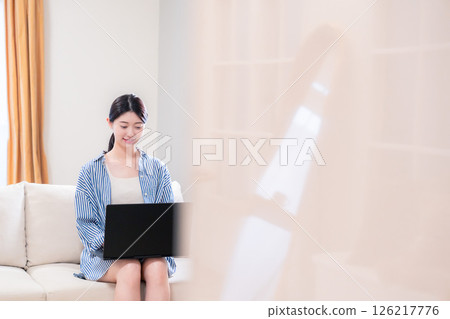 年輕女子在家放鬆並使用筆記型電腦 年輕女子在家放鬆並使用筆記型電腦 126217776