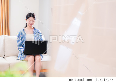 年輕女子在家放鬆並使用筆記型電腦 年輕女子在家放鬆並使用筆記型電腦 126217777