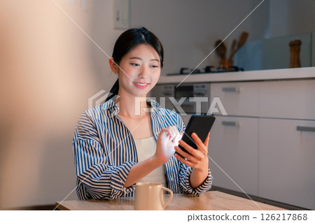 深夜使用智慧型手機的微笑年輕女子 深夜使用智慧型手機的微笑年輕女子 126217868