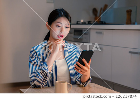 深夜使用智慧型手機的微笑年輕女子 深夜使用智慧型手機的微笑年輕女子 126217874