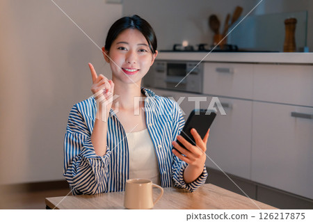 Smiling young woman using a smartphone late at night 126217875
