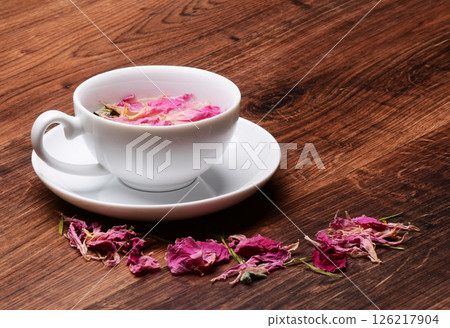 Aromatic Herbal Rose Tea with Blossoms on Wooden Table. Isolated Black background. International Tea Day. Older International Tea Day. UK National Tea Day. Japan Chanoyu Aromatic Herbal Rose Tea with Blossoms on Wooden Table. Isolated Black background. International Tea Day. Older International Tea Day. UK National Tea Day. Japan Chanoyu 126217904