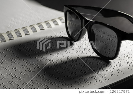 Homemade book. The Braille alphabets from A to Z in alphabetical order. Glasses on Braille written homemade book as concept for World Braille Day Homemade book. The Braille alphabets from A to Z in alphabetical order. Glasses on Braille written homemade book as concept for World Braille Day 126217971