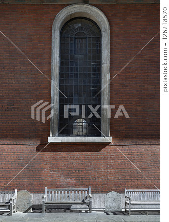 a view from the side of St Paul's Church is England parish church with tall glass window on red brick wall and wooden benches. a view from the side of St Paul's Church is England parish church with tall glass window on red brick wall and wooden benches. 126218570