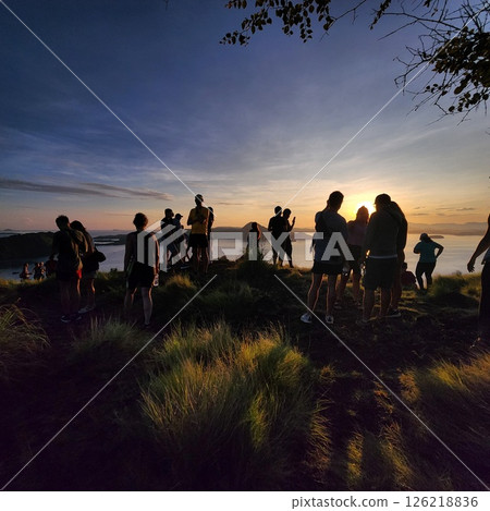 Watching the sunrise from a mountaintop with friends 126218836