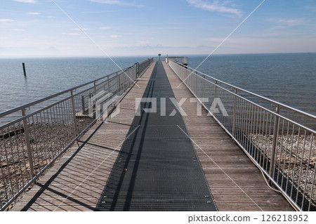 A pier with a wooden walkway leading to the water 126218952