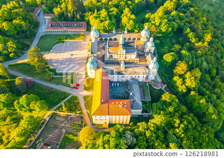 Set atop a hill, the baroque complex of Holy Mountain in Pribram is a significant pilgrimage site surrounded by lush greenery. Visitors admire the architecture and tranquil atmosphere. 126218981