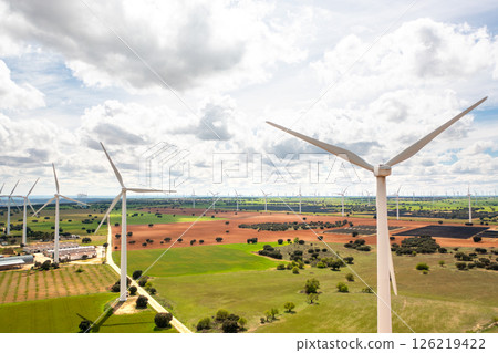 Drone shot of wind turbines turning slowly across 126219422