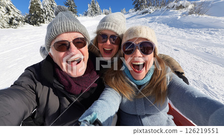 Joyful seniors enjoying skiing together in winter 126219551