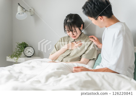 A woman suffering from chest pain, palpitations, asthma, and angina, and a worried man A woman suffering from chest pain, palpitations, asthma, and angina, and a worried man 126220841