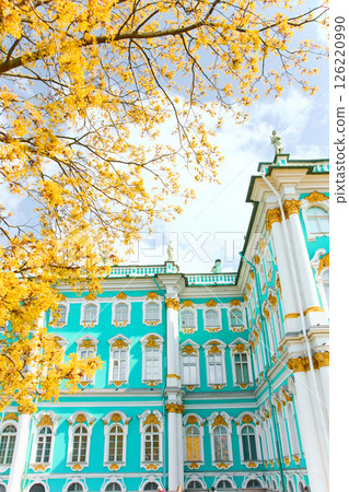 the incredibly picturesque facade of the Winter Palace through the branches of trees on a clear spring day, the heritage of Russia, the most famous landmark of St. Petersburg, the museum the incredibly picturesque facade of the Winter Palace through the branches of trees on a clear spring day, the heritage of Russia, the most famous landmark of St. Petersburg, the museum 126220990
