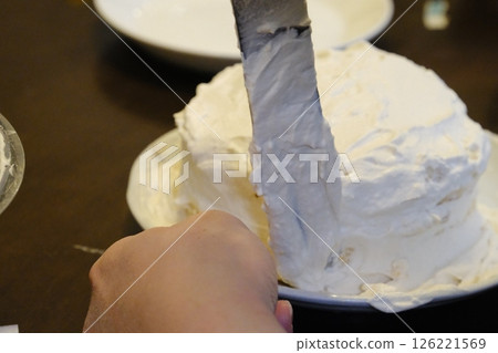 Japanese hands spreading cream on handmade sponge cake Japanese hands spreading cream on handmade sponge cake 126221569