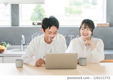 一對友善的夫婦一邊看電腦一邊放鬆和交談（丁克、情侶、放鬆） 126221772