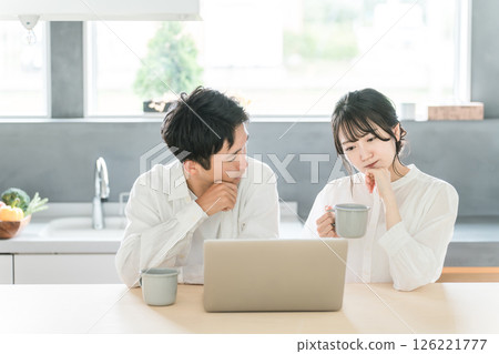 Couples having a family meeting while looking at a computer (investment, savings, asset management, investment trusts) 126221777