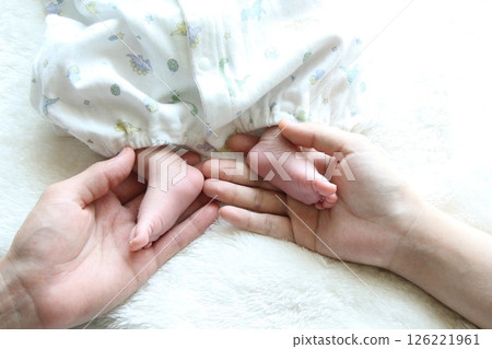 Newborn baby's tiny feet and mom and dad's hands 126221961