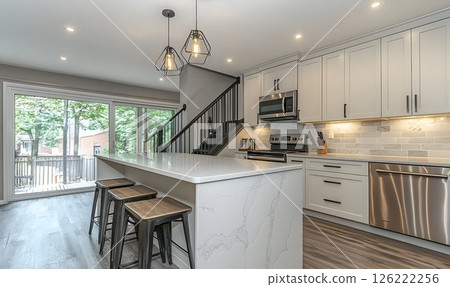 Modern Kitchen Interior with Island, Geometric Lights, and Stair 126222256