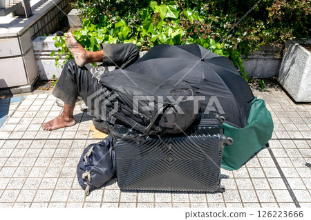 Homeless luggage and homeless people placed on the sidewalk Homeless luggage and homeless people placed on the sidewalk 126223666