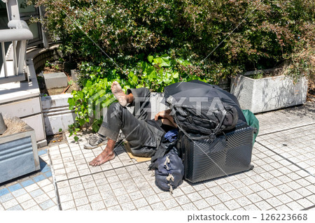 無家可歸的行李和無家可歸的人被放置在人行道上 126223668