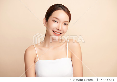 A beautiful young Asian woman with clean, fresh skin against a beige background. Skincare, facial treatment, cosmetology, beauty, and spa. An elegant portrait of an Asian woman. A beautiful young Asian woman with clean, fresh skin against a beige background. Skincare, facial treatment, cosmetology, beauty, and spa. An elegant portrait of an Asian woman. 126223784