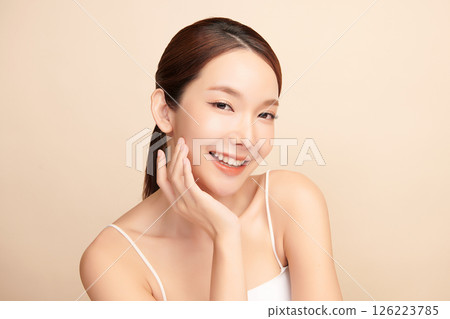A beautiful young Asian woman with clean, fresh skin against a beige background. Skincare, facial treatment, cosmetology, beauty, and spa. An elegant portrait of an Asian woman. A beautiful young Asian woman with clean, fresh skin against a beige background. Skincare, facial treatment, cosmetology, beauty, and spa. An elegant portrait of an Asian woman. 126223785