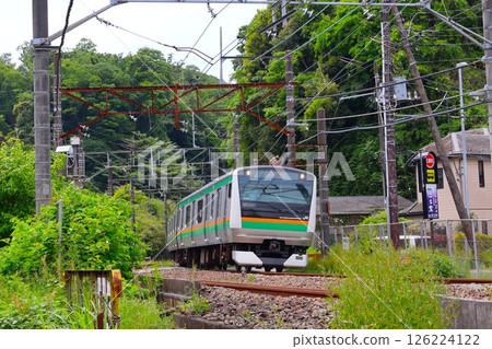 A Yokosuka Line train passing through the Third Kamakura Road railroad crossing heading towards Kita-Kamakura Station 126224122