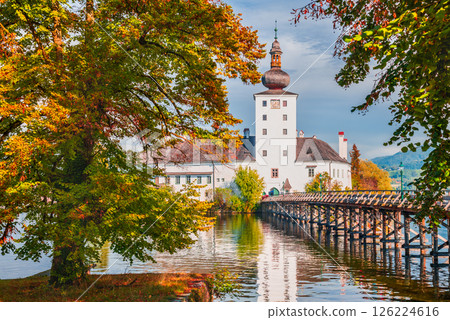 Schloss Ort, Austria surrounded by autumn-colored trees, reflects on Traunsee waters 126224616