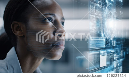 A young woman with in front of a big monitor in the middle of a modern server room. Collection and storage of large amounts of data. The young woman ensures efficient data storage in the server room. 126225814