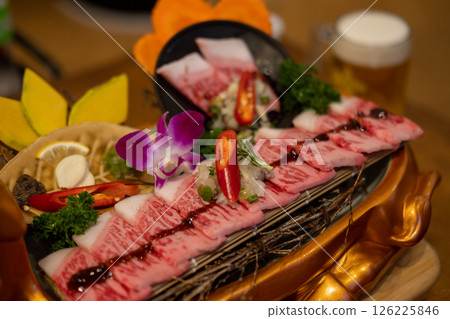 Japanese style sliced beef prepared on the plate, with flower decoration Japanese style sliced beef prepared on the plate, with flower decoration 126225846
