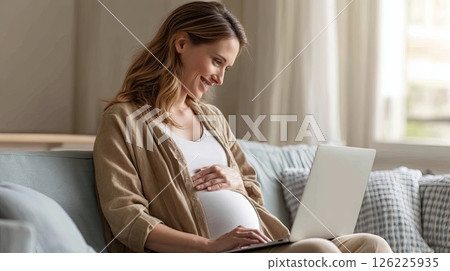 Happy pregnant mom working remotely on laptop. Online video call. A happy pregnant woman connects with her team online, showcasing the beauty of remote work. 126225935