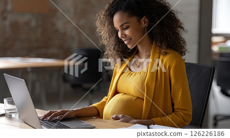 Young pregnant Asian woman in front of laptop monitor at home. A joyful pregnant woman chats with her doctor online, excitedly discussing her pregnancy journey. 126226186