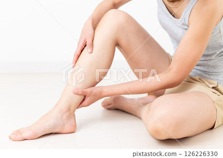 一位穿著夏裝的中年婦女關心她的腿部身體護理 一位穿著夏裝的中年婦女關心她的腿部身體護理 126226330
