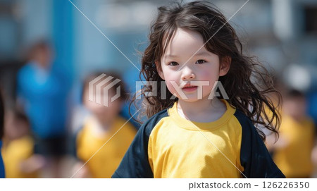 A cute kindergarten girl with a serious expression on the kindergarten grounds 126226350