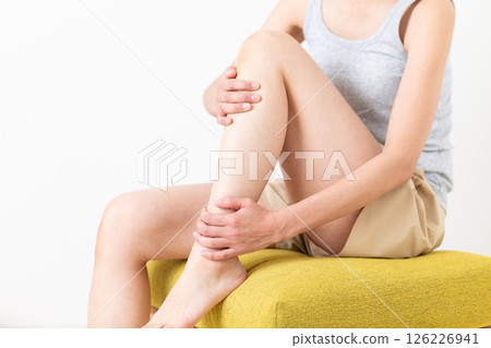 A middle-aged woman in summer clothes who is concerned about her leg body care 126226941