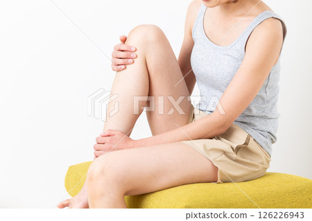 一位穿著夏裝的中年婦女關心她的腿部身體護理 126226943