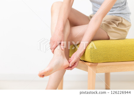一位穿著夏裝的中年婦女關心她的腿部身體護理 126226944