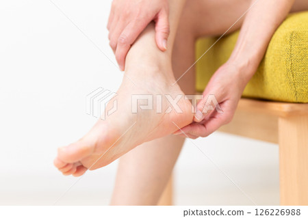 A middle-aged woman in summer clothes who is concerned about her heels 126226988