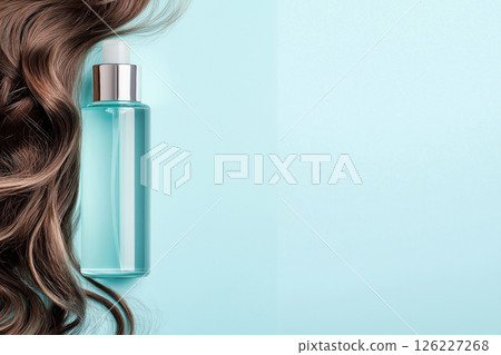 Minimalistic composition featuring a blue shampoo bottle and elegant brown hair strands on turquoise. The image emphasizes beauty, haircare, and luxury with a clean and modern aesthetic. 126227268
