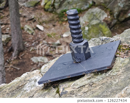Plate and anchor bolt. Structural support on natural stone with gap to plate and anchor bolt in rocky base Plate and anchor bolt. Structural support on natural stone with gap to plate and anchor bolt in rocky base 126227434